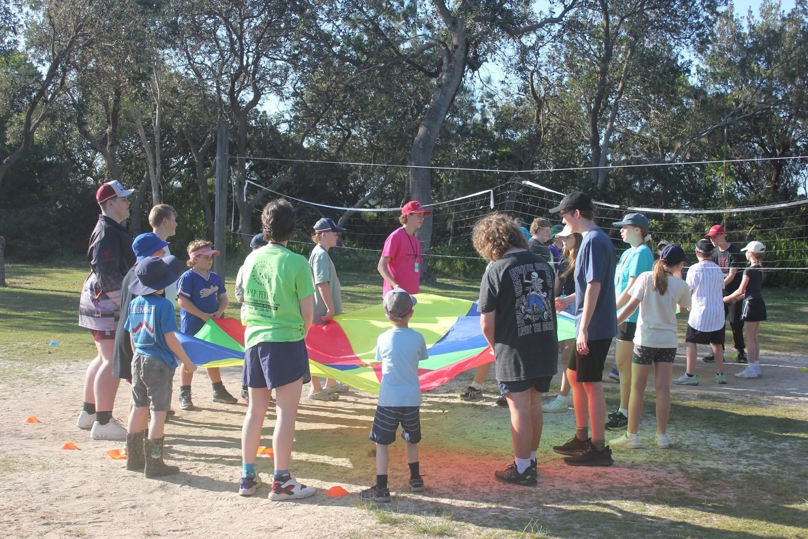 Camp Perthes volunteers and kids holding a colorful parachute